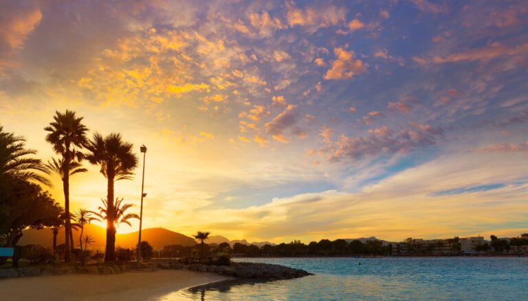 SonnenunteDie besten Reisetipps für Mallorca, die du kennen solltestrgang am Strand mit Palmen